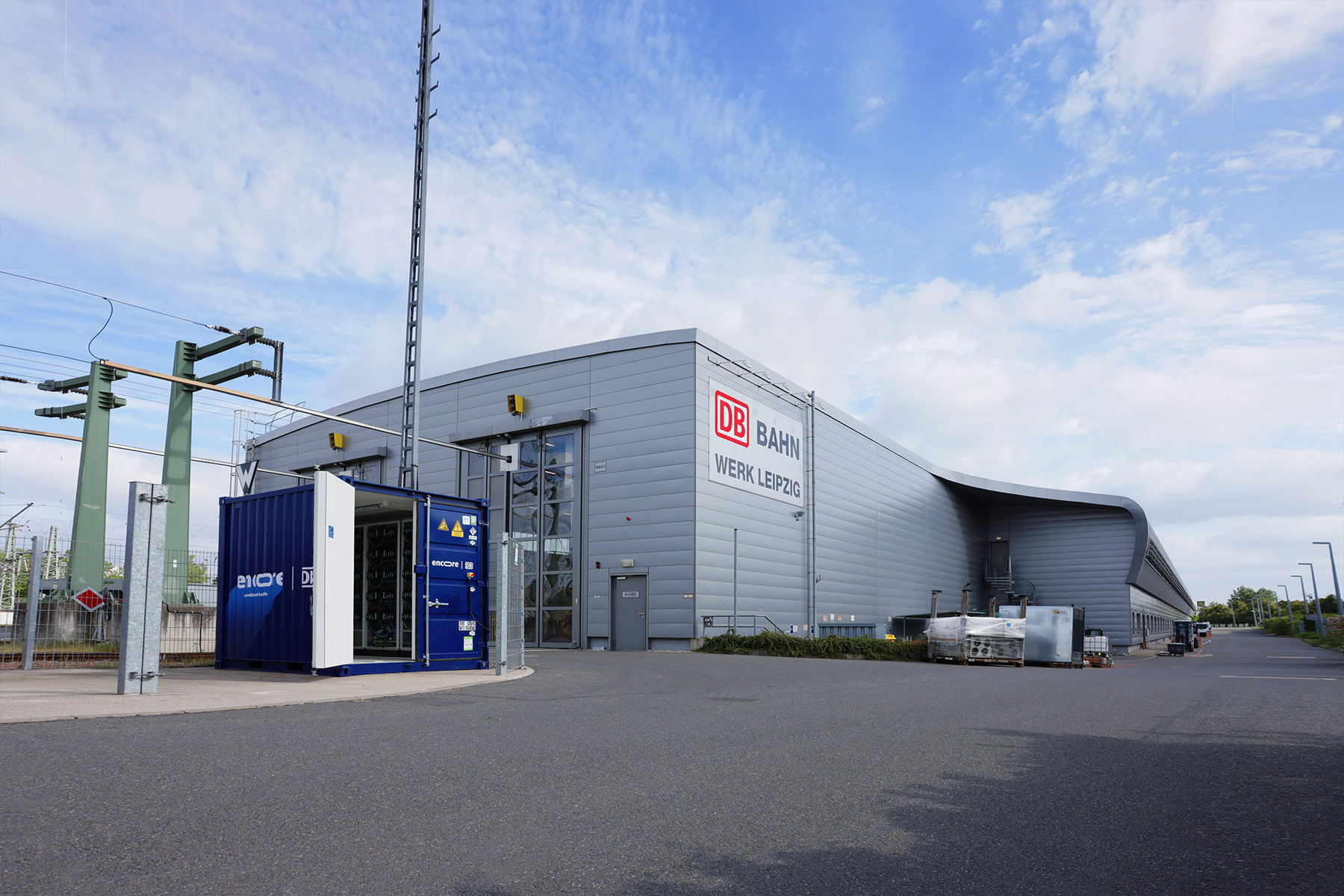 blauer 10-Fuß Container mit geöffneter Tür und encore | DB Schriftzug vor ICE-Werk in Leipzig