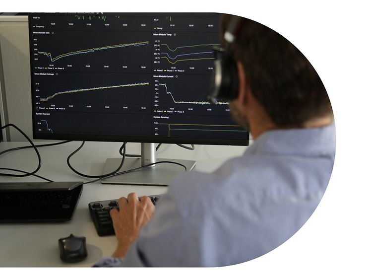 Ein Mitarbeiter von encore | DB sitzt mit Headset am Computer und schaut auf die Diagramme der Standortanalyse. 