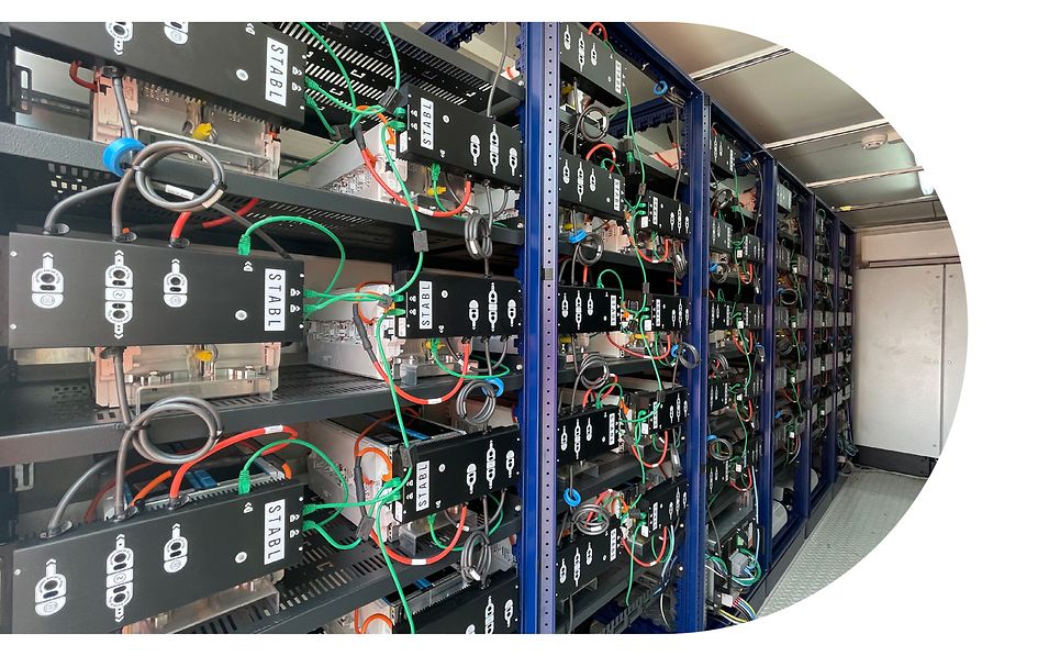 Innenansicht des Batteriespeichers von encore | DB. Verschaltete Batteriemodule und Wechselrichter in Lastenregalen. 