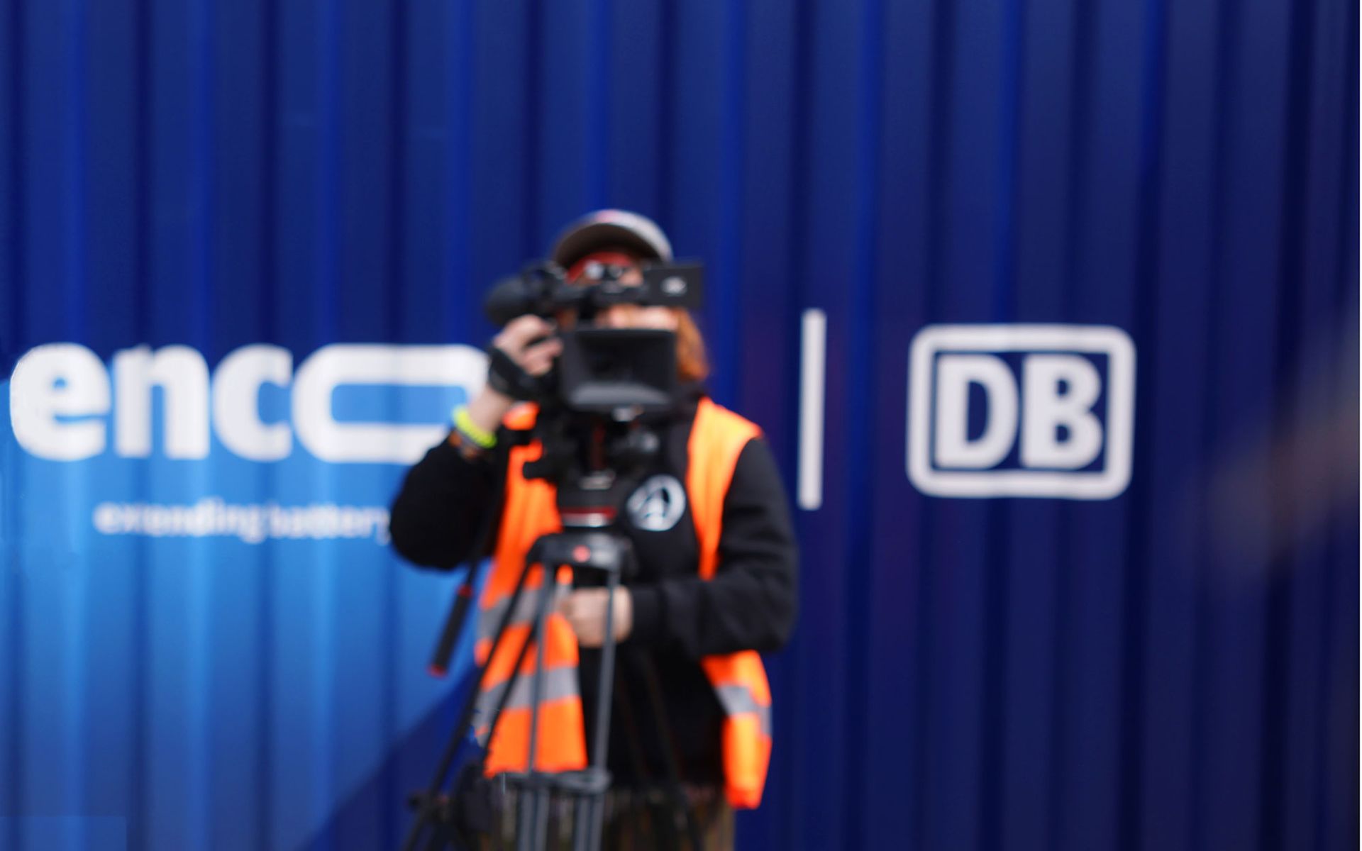 Videographin hinter Kamera, vor blauem encore | DB Batteriespeicher