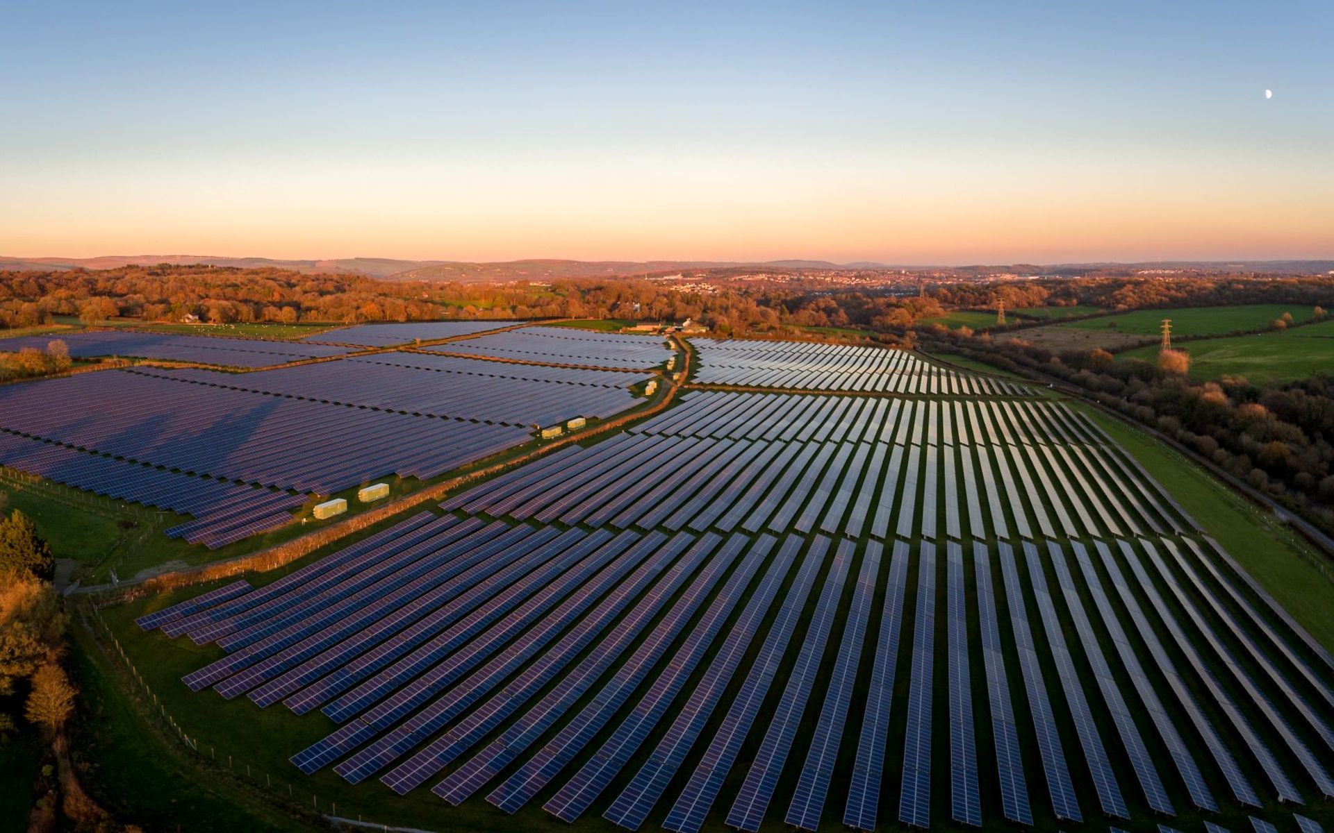 Luftaufnahme von Solarzellen in einem PV-Park im Abendlicht.